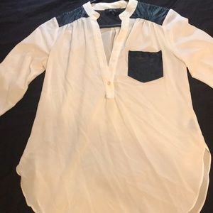 Flowy white top with faux leather pocket and top of shoulders.